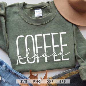 May include: An olive green sweatshirt with the words "COFFEE please" in white block and script lettering. The sweatshirt is paired with blue jeans, a brown hat, and a fall-themed scarf.