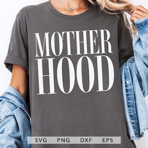 May include: Dark gray t-shirt with the word "MOTHERHOOD" in large, white, bold letters. The shirt is a casual style, with rolled-up sleeves. The bottom of the image shows the file types: SVG, PNG, DXF, and EPS.