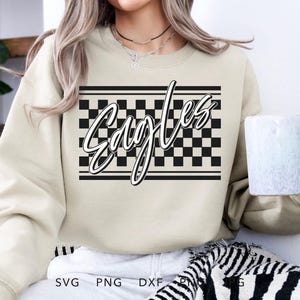 May include: A beige sweatshirt with a black and white checkered pattern and the word "Eagles" in a stylized font.