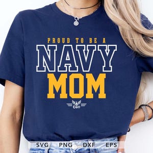 Könnte beinhalten: Marineblaues T-Shirt mit dem Text "PROUD TO BE A NAVY MOM" in weißen und gelben Blockbuchstaben. Das Design enthält ein kleines Emblem unter dem Wort "MOM". Ein lässiges T-Shirt für eine Navy-Mutter.