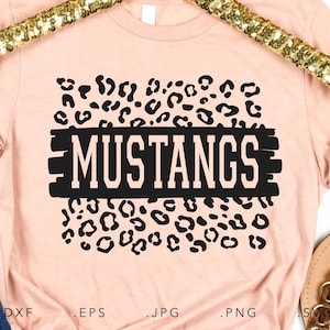 May include: A pink t-shirt with a black leopard print design and the word "MUSTANGS" in white letters on a black stripe.