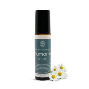 May include: A brown glass roll-on bottle with a black cap and a white label that says "OPAL MASSAGE THERAPY" and "Chamomile ROLL-ON". The bottle is sitting on a white background with a few white daisies.