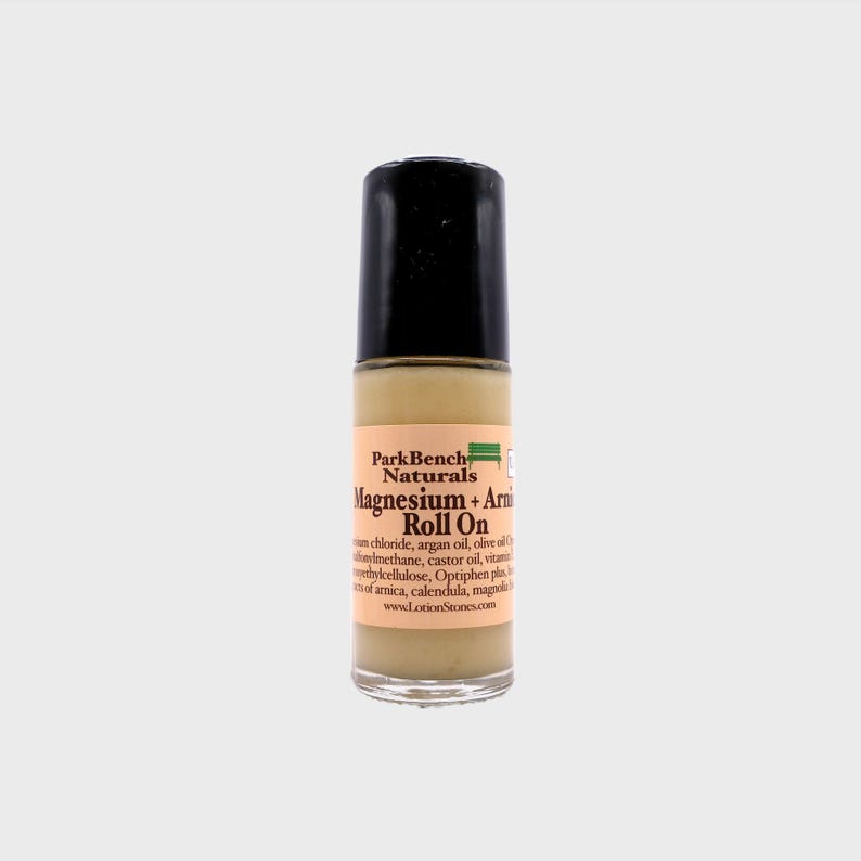 Pu&ograve; includere: Un flacone trasparente roll-on con tappo nero e un'etichetta che recita "Park Bench Naturals Magnesium + Arnica Roll On".
