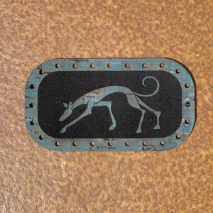 May include: A blue and black oval-shaped wooden plaque with a stylised grey silhouette of a running dog on a black background.