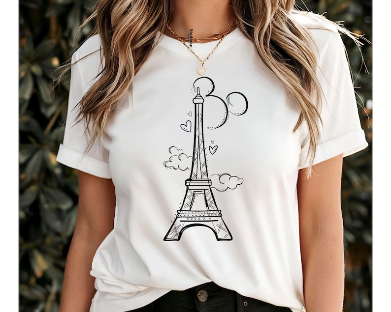 K&ouml;nnte beinhalten: Wei&szlig;es T-Shirt mit einer schwarzen Strichzeichnung des Eiffelturms, drei Kreisen, Wolken und Herzen. Das Design ist zentriert. Das T-Shirt hat kurze &Auml;rmel und bietet einen l&auml;ssigen Stil. Das Design ist einfach und stilvoll.
