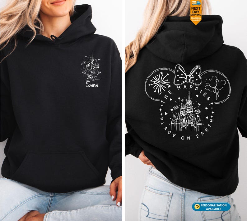 May include: Black hooded sweatshirt with a front pocket. The front features a white graphic and the name "Sara". The back displays a white design of Mickey Mouse ears, a bow, fireworks, and a castle with the text "The Happiest Place on Earth".