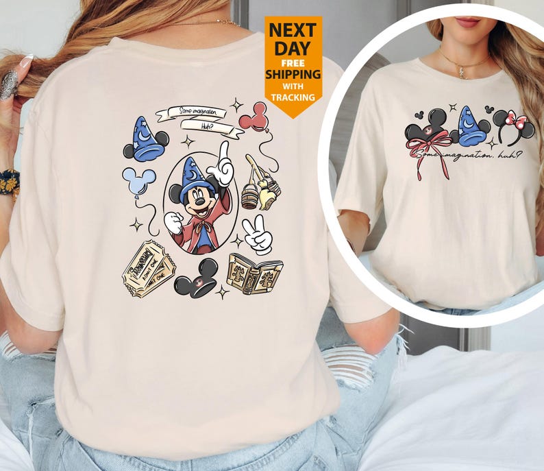 May include: Cream-colored t-shirt featuring a Mickey Mouse graphic. The design includes Mickey Mouse in a sorcerer's hat, along with other Disney-themed elements. The text "Some imagination, huh?" is also present.