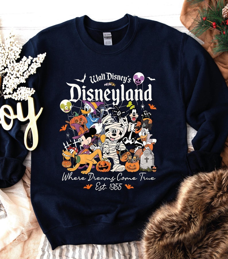 May include: Navy blue sweatshirt with a Halloween-themed Disneyland design. The graphic features Disney characters in costumes, including Mickey Mouse and Donald Duck, with the text "Walt Disney's Disneyland" and "Where Dreams Come True Est. 1955".