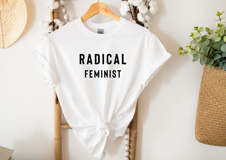 May include: White t-shirt with black text that reads "RADICAL FEMINIST".