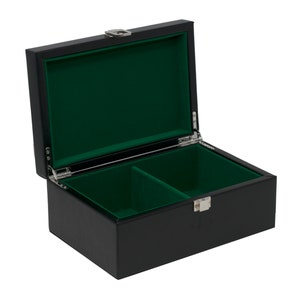 Könnte beinhalten: Geöffnete, schwarze Box mit grünem Samtinnenfutter. Die rechteckige Box hat einen Klappdeckel und einen silberfarbenen Verschluss. Das Innere ist in zwei Fächer unterteilt.