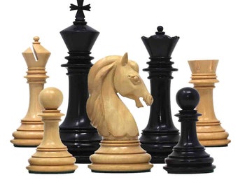 May include: A selection of chess pieces, including a black king, queen, and pawn, and a light-coloured knight, rook, and pawn. The pieces are made of wood and have a classic design. The chess set is displayed on a white background.