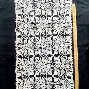 May include: White crocheted doily with a delicate floral pattern. The doily is rectangular and measures approximately 18 inches by 30 inches.