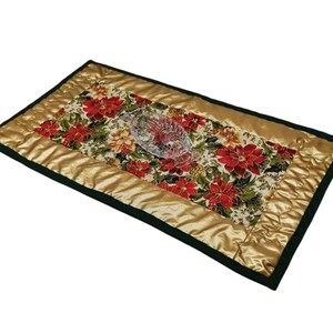 Könnte beinhalten: Ein goldfarbener und grüner gesteppter Tischläufer mit einem roten Weihnachtsstern-Blütenmuster. Der Läufer hat einen dunkelgrünen Rand und eine goldfarbene Satin-Mittelbahn.