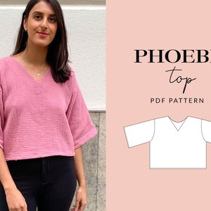 Può includere: Un top rosa, corto, con scollo a V e maniche a 3/4. Il top è realizzato in un tessuto strutturato. L'immagine mostra anche un disegno a linea del modello del top, con il testo "PHOEBE top PDF PATTERN".