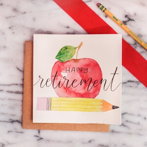 May include: A watercolor card with a red apple and a yellow pencil. The apple has the words "Happy retirement" written on it.