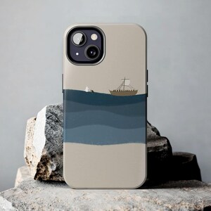 Op de afbeelding: Een beige telefoonhoesje met een blauwe en witte illustratie van een zeilboot op de oceaan. Het hoesje heeft een zwarte uitsparing voor de camera lens.