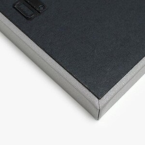 May include: Close-up of the edge of a canvas print, showing the gray canvas wrapped around the edges and a black backing.