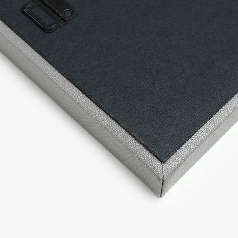 May include: Close-up of the edge of a canvas print, showing the gray canvas wrapped around the edges and a black backing.