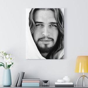 May include: Black and white portrait of a man with long hair and a beard. He is wearing a white robe and looking directly at the viewer. The image is a close-up of his face.
