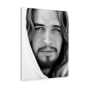 May include: Black and white portrait of a man with long hair and a beard. He is looking directly at the viewer with a gentle expression. The man is wearing a white robe.