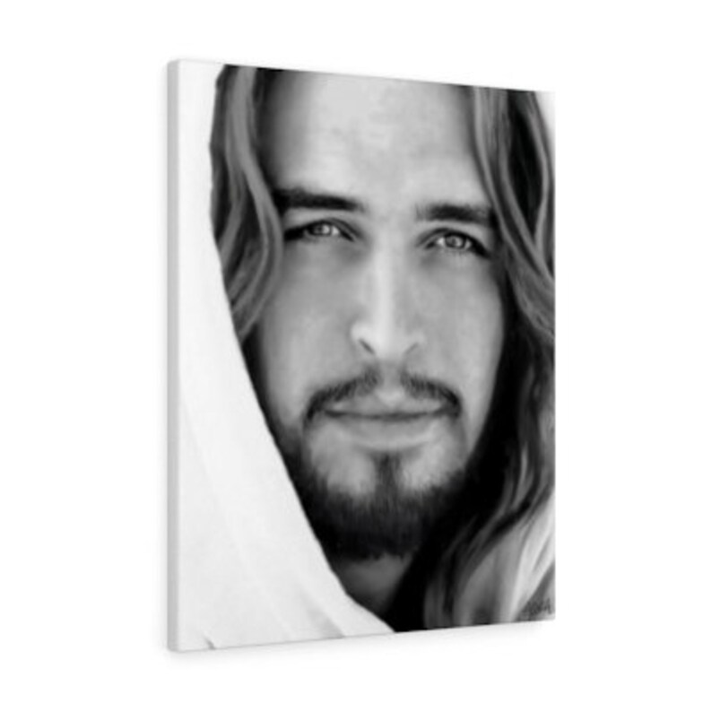 May include: Black and white portrait of a man with long hair and a beard. He is looking directly at the viewer with a gentle expression. The man is wearing a white robe.