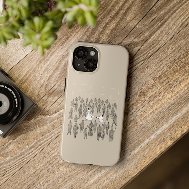 May include: A beige iPhone case with a black and white illustration of a couple dancing in a crowd of people.