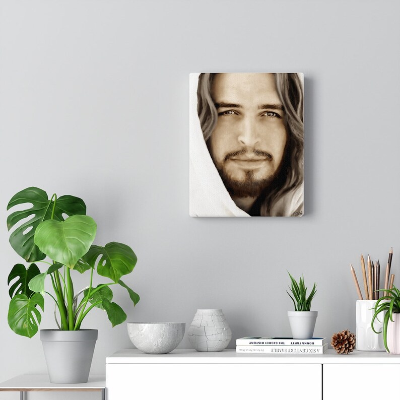 May include: A sepia toned painting of a man with long hair and a beard. He is wearing a white robe and looking directly at the viewer. The painting is on a canvas and has a white frame.