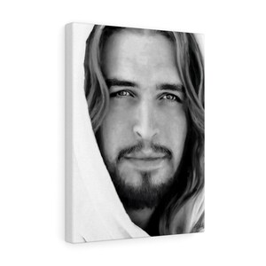 May include: Black and white portrait of a man with long hair and a beard. He is looking directly at the viewer with a serious expression. The image is cropped to show only his face and shoulders.