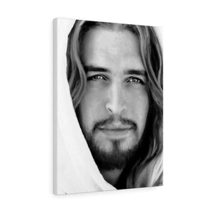 May include: Black and white portrait of a man with long hair and a beard. He is wearing a white robe and looking directly at the viewer.
