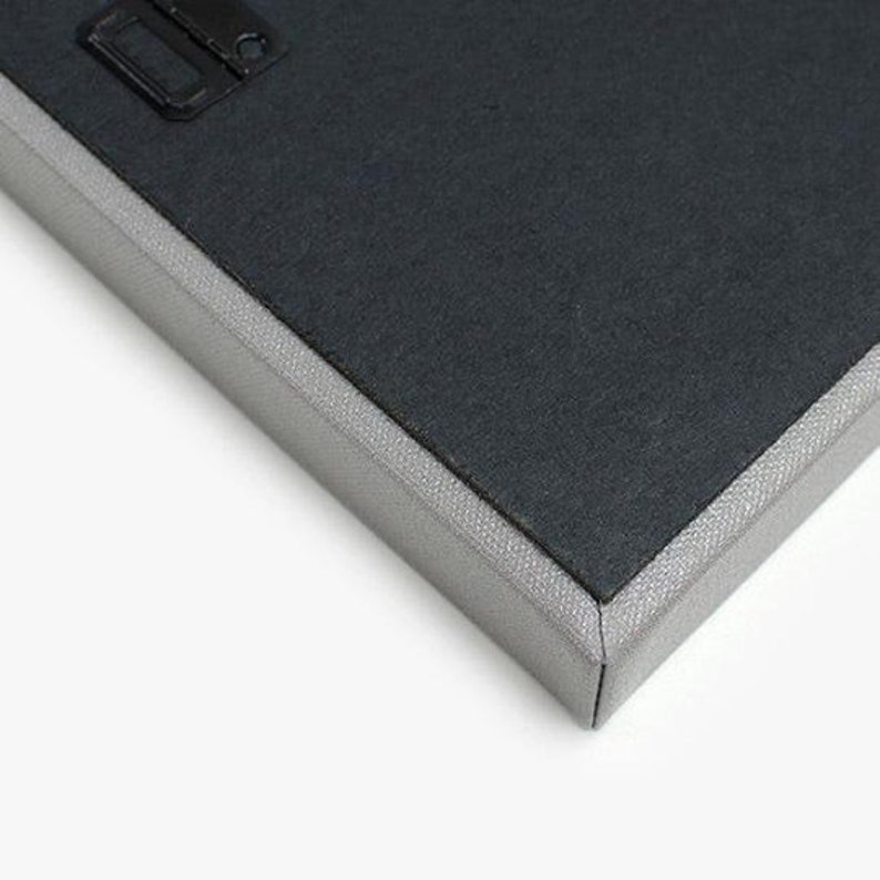 May include: Close-up of the edge of a canvas print with a gray frame. The canvas is stretched over a wooden frame and has a textured surface.