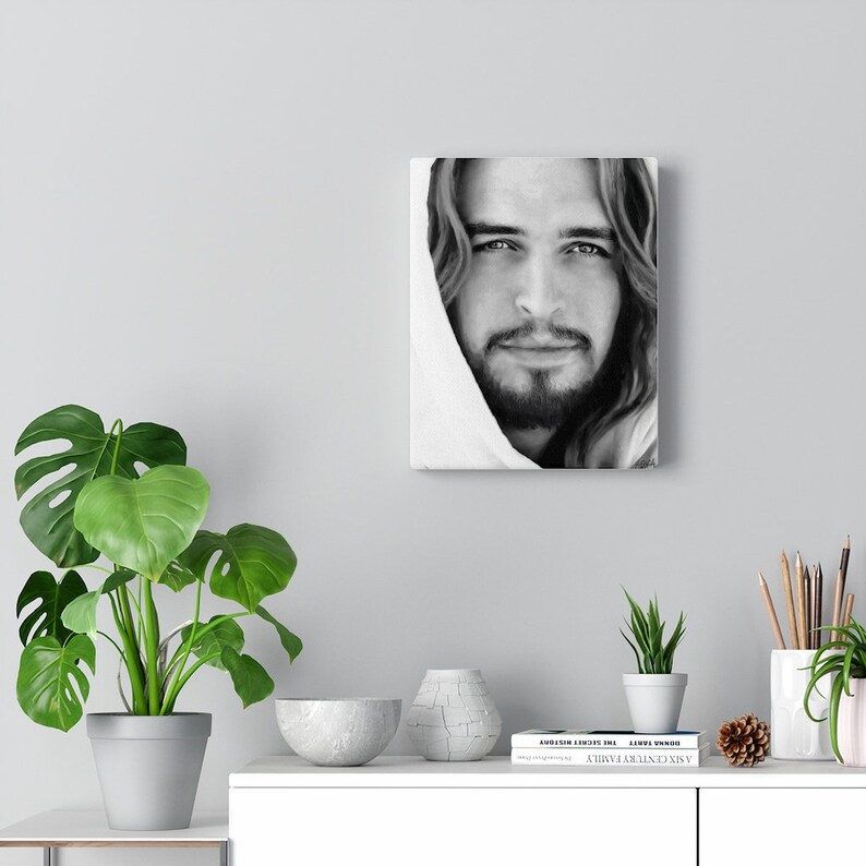 May include: Black and white portrait of a man with long hair and a beard. He is wearing a white robe and looking directly at the viewer. The image is printed on canvas.