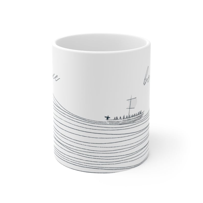 May include: White ceramic mug with a black and white illustration of a ship sailing on a wavy line pattern. The text "be" is on the right side of the mug and "peace" is on the left side.