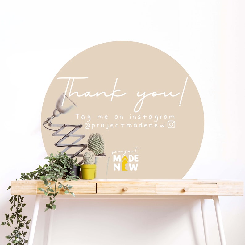 Może przedstawiać: Beżowe koło z tekstem "Thank you!" i "Tag me on instagram @projectmadenew" na białej ścianie. Na pierwszym planie znajdują się dwie małe doniczki z kaktusami i lampa na drewnianym biurku.
