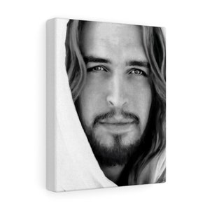 May include: Black and white portrait of a man with long hair and a beard. He is wearing a white robe and looking directly at the viewer.