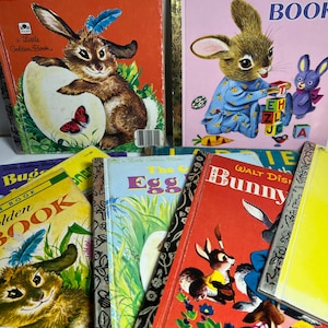 May include: A collection of vintage children's books featuring bunnies and eggs. The books have colourful covers with illustrations of bunnies, eggs, and other springtime imagery. The titles include "The Golden Egg Book", "The Bunny Book", "Bugs Bunny Book", and "The Egg".