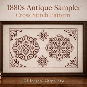 May include: Framed cross-stitch pattern with the text "1880s Antique Sampler Cross Stitch Pattern." The sampler features two large and two small ornate, symmetrical designs in shades of brown. A candle and books sit to the left, and a vase of flowers is on the right.