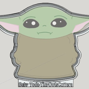 May include: A green and brown cookie cutter in the shape of Baby Yoda from the Star Wars series. The cookie cutter is designed to be used for making cookies or other baked goods.