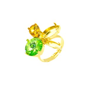 Puede incluir: Un anillo dorado con tres piedras preciosas. El anillo tiene una piedra preciosa verde brillante grande y redonda y una piedra preciosa amarilla redonda más pequeña. El diseño del anillo incluye detalles dorados en forma de pétalos.