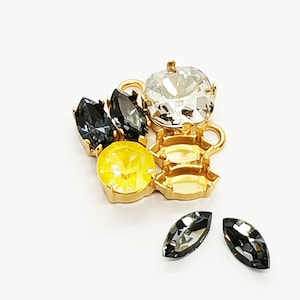 May include: A set of gold-tone metal connector charms with clear, yellow, and black rhinestones. The charms are designed to be used in jewelry making.
