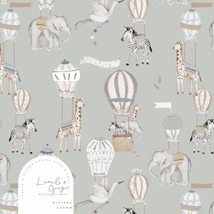 以下が含まれることがあります： シマウマ、キリン、ゾウ、コウノトリが熱気球に乗った水彩イラストが特徴の気まぐれなパターン。デザインには、グレー、ベージュ、白の柔らかな色調の旗や装飾要素が含まれています。「Lumelo & Ginger Design Studio Riviera 220mm」の文字が見えます。