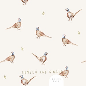 May include: A repeating pattern of watercolor pheasants in shades of brown, tan, and blue on a cream background. The design includes small green leaf accents and the text "LUMELO AND GINGER" and "220 MM CARD".