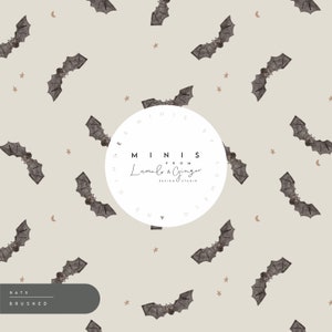 May include: A seamless pattern featuring gray bats on a light beige background. The pattern also includes small gold stars and crescent moons. The text "MINIS FROM Lumi & Ginger DESIGN STUDIO" is in a white circle.