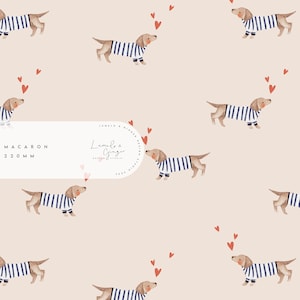 Può includere: Uno schema senza cuciture con un design ripetitivo di cani bassotti marroni e bianchi che indossano camicie a righe blu e bianche. I cani sono circondati da piccoli cuori rossi. Il testo "MACARON 220MM" e un logo per "Lumie & Ginger Design Studio" sono anche inclusi nello schema.