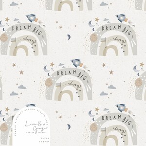 May include: A seamless pattern featuring a light blue rocket, a rainbow arch with the text "DREAM BIG...always", and stars on a white background. The pattern is designed by Lumela & Ginger Design Studio.