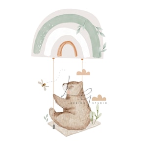 Puede incluir: Una ilustración de acuarela de un oso marrón sentado en un columpio hecho de un arcoíris. El oso mira hacia la izquierda y hay una pequeña abeja volando cerca. El fondo es blanco con algunas nubes.