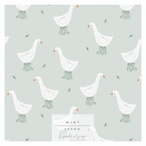 Pode incluir: Um padrão sem costura com gansos brancos usando botas de chuva verdes em um fundo azul claro com pequenas folhas verdes. O texto "MINT 200MM Lumi & Ginger DESIGN STUDIO" está na parte inferior do padrão.