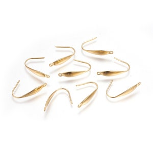 May include: Eight gold-toned earring hooks with a flat, oval-shaped design. The hooks are made of metal and have a smooth finish.