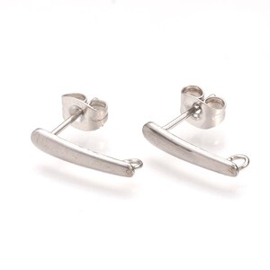May include: A pair of silver earring findings with a curved bar and a jump ring. The findings are designed to be used with other jewelry components.