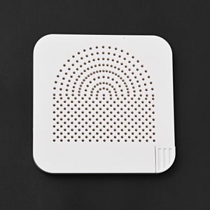 May include: White plastic square with a circular pattern of small holes. The holes are arranged in concentric circles.