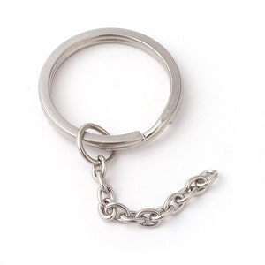 May include: A silver key ring with a split ring and a silver chain attached.